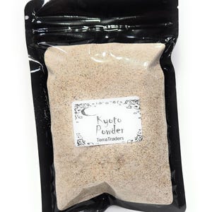 May include: A black, resealable pouch filled with light brown powder. A white label with the text "Kyoto Powder" and "Terra Traders" is affixed to the front of the pouch. The powder appears to be finely ground.