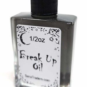 May include: A small, clear glass bottle with a black cap, containing a dark liquid. The bottle has a white label with the text "1/2oz Freak Up Oil TerraTraders.com".