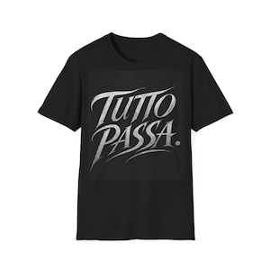 Pode incluir: T-shirt preto com a frase italiana "Tutto Passa" em branco, com letras cursivas. O texto está centrado no peito. A camisa tem gola redonda e mangas curtas.