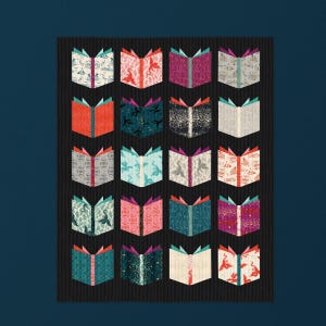 May include: A quilt featuring a grid of twenty open book blocks arranged in five rows and four columns. Each book block displays a unique fabric pattern, including floral, dragon, and geometric motifs, set against a dark vertical striped background.