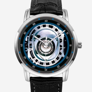 Könnte beinhalten: Eine Armbanduhr mit silberfarbenem, rundem Gehäuse und schwarzem Lederarmband. Das Zifferblatt zeigt eine detaillierte mechanische Grafik eines Rotationsmotors in Silber und Schwarz, mit weißen Zeigern und einem dünnen silbernen Sekundenzeiger.