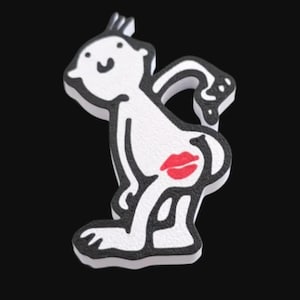 May include: A white cartoon figure with black outlines and a red lip print on the rear. The figure is in a playful pose, with a small tuft of hair on top. The background is solid black.