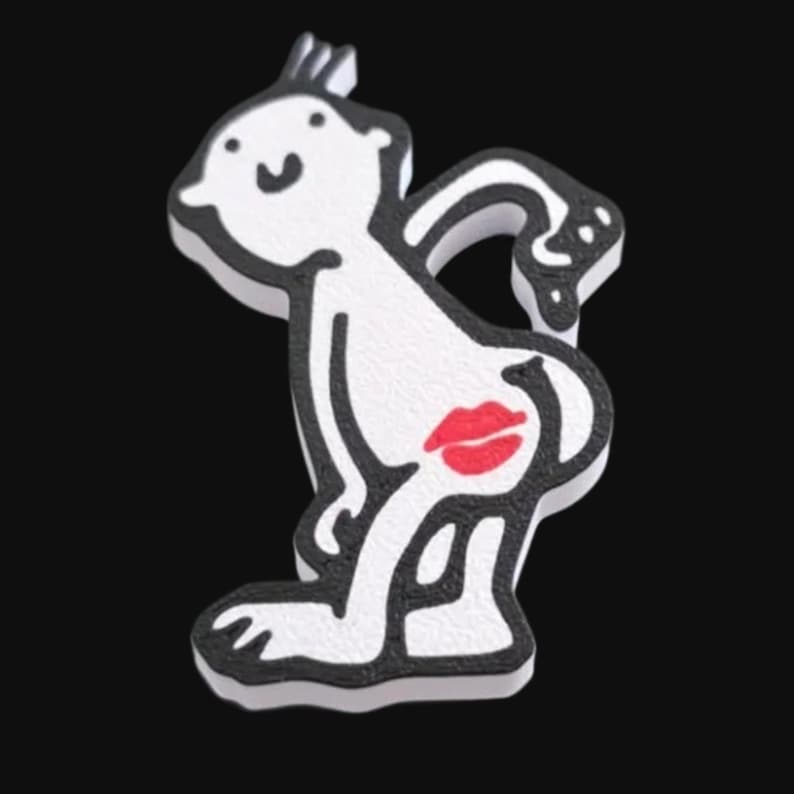 May include: A white cartoon figure with black outlines and a red lip print on the rear. The figure is in a playful pose, with a small tuft of hair on top. The background is solid black.