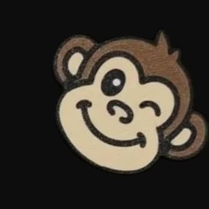 May include: A smiling monkey face with a winking eye, rendered in brown, tan, and black. The monkey's face is tan with brown outlines and ears. The background is solid black.