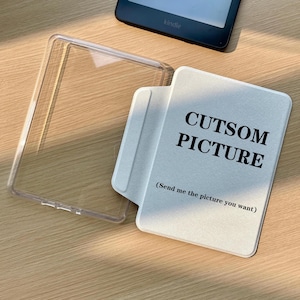 May include: A clear plastic e-reader case and a white e-reader cover with the black text CUTSOM PICTURE and the parenthetical instruction (Send me the picture you want) printed on the front surface, positioned near a black e-reader device.