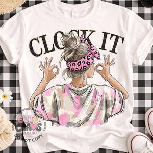 May include: White t-shirt with the text "CLOCK IT" in black letters. The shirt features a graphic of a woman with her hands in the "OK" gesture, wearing a pink leopard print headband and a tie-dye shirt.