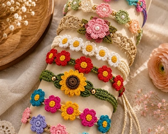 May include: A collection of eight colorful crochet flower bracelets displayed on a cylindrical stand. Each bracelet features intricate yarn-stitched floral patterns in various hues, accented with small beads, and finished with adjustable braided ties.