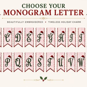 May include: A digital display showing the alphabet from A to Z, with each letter embroidered in dark green on a light pink vertical banner. Each banner features a small red and white Santa hat perched on the letter, with holly accents.