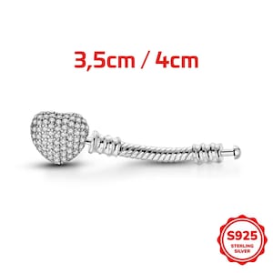 Op de afbeelding: Een zilveren bedel met een hartvormige hanger bedekt met heldere stenen, bevestigd aan een getextureerde, cilindrische connector. De tekst 3,5cm / 4cm is zichtbaar boven de bedel en een S925 Sterling Silver zegel staat in de hoek.