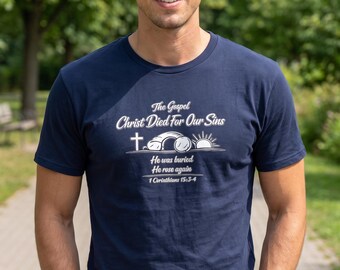 May include: A navy blue short-sleeve t-shirt featuring white text that reads The Gospel Christ Died For Our Sins, He was buried, He rose again, 1 Corinthians 15:3-4, accompanied by a graphic of a cross, an open tomb, and a rising sun.