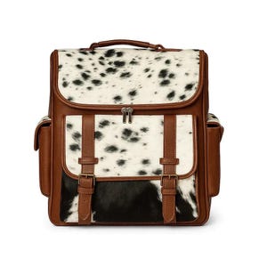 May include: A backpack featuring a brown leather-like trim and a black and white cowhide-style pattern. The bag includes a top handle, a zippered main compartment, a front pocket with two buckled straps, and two side pockets on the exterior.