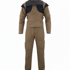 May include: A tan long-sleeved shirt and matching pants set featuring a dark charcoal quilted chest panel, shoulder accents, and side buckle straps. The pants include reinforced knee patches, creating a structured utility-style outfit.