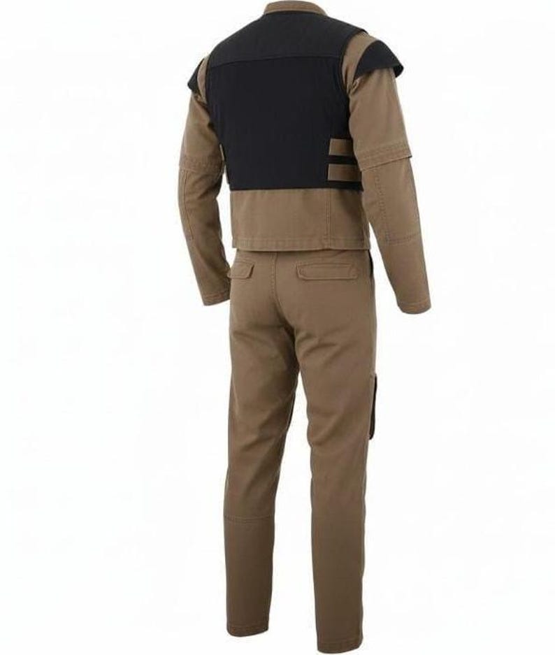 May include: A tan long-sleeved jacket and matching trousers set. The jacket features a black panel across the upper back and shoulders. The trousers have two back pockets and a straight-leg cut. The entire outfit is made of a solid tan fabric.