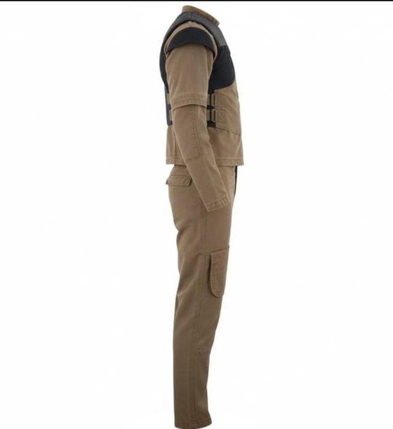 May include: A tan long-sleeve jumpsuit featuring a black vest overlay on the upper torso. The garment includes a high collar, long sleeves, and long trousers with a visible side pocket on the thigh. The vest section has side buckle closures.
