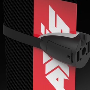 May include: A black and white device with a strap, attached to a red and white surface. The device has a cylindrical shape with a black body and a white top. The surface has a carbon fiber pattern.