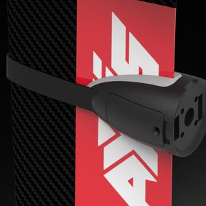 May include: A black and white device with a strap is attached to a red and white surface. The device has a rounded shape with a rectangular section and a circular opening. The background is black.