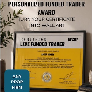 May include: A framed certificate titled CERTIFIED LIVE FUNDED TRADER with a yellow and white background. The text includes AMEER OAKLEY, JANUARY 07, 2025, and TOPSTEP. A gold seal and signature are visible. The frame is black and rectangular.