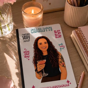 Può includere: Un quaderno bianco con un'illustrazione a cartoni animati di una persona con lunghi capelli castani ricci che tiene in mano un bicchiere da cocktail. La copertina include il testo Charlotte, I'm not always sassy I do sleep, slay slay slay, slay the day, make today great e inspirational.