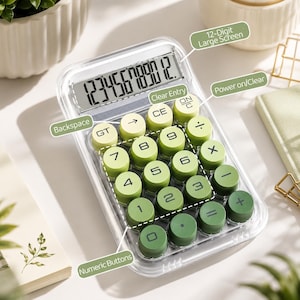 Peut inclure: Une calculatrice de bureau avec un boîtier transparent et un grand écran à 12 chiffres. L'appareil dispose de touches rondes et surélevées dans un dégradé de tons verts, allant du vert citron clair au vert forêt foncé, avec des chiffres et fonctions.