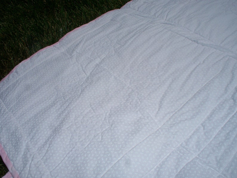 38 x 38 Baby Quilt with Light Pink and White Floral Prints White on White Floral Back and Pink Trim.
