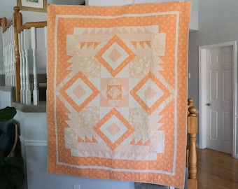 60" x 70" Peach Quilt. This soft peach colored quilt has flowers and a fun abstract pattern. It's the perfect throw quilt. Car, picnic, bed.