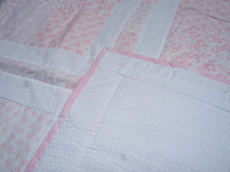 38 x 38 Baby Quilt with Light Pink and White Floral Prints White on White Floral Back and Pink Trim.