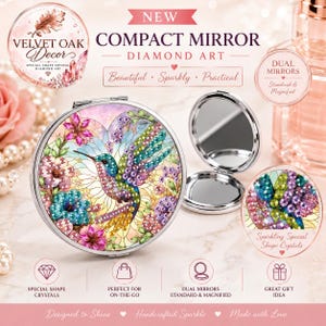 Pode incluir: Um espelho de bolso redondo prateado com um design de arte de diamante de um beija-flor rodeado por flores coloridas. O espelho é mostrado fechado e aberto, revelando dois espelhos no interior. A superfície é decorada com cristais cintilantes.