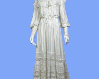 Op de afbeelding: Een witte maxi-jurk met een kanten kraag en lange mouwen. De jurk heeft een getailleerde taille en een gelaagde rok met kanten rand.