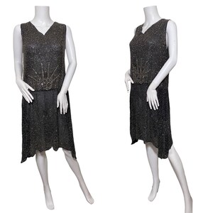 May include: A sleeveless black beaded flapper dress with a geometric design of silver beads on the bodice.