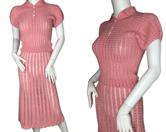 May include: A pink knitted two-piece set with a collared top and a skirt. The top has short sleeves and a button closure. The skirt is knee-length and has a flared silhouette.
