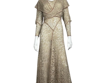 May include: A long, beige lace dress with a fitted bodice and a flowing skirt. The dress has a scoop neckline and long sleeves. The lace is delicate and intricate, with a floral pattern.
