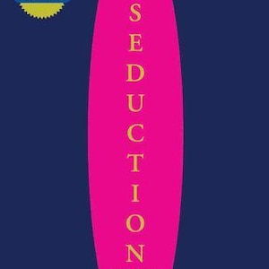 May include: A book cover with a dark blue background and a large, vertical hot pink oval in the center. The text reads The Concise ART OF SEDUCTION by Robert Greene, A Joost Elffers Book. A yellow starburst badge says INTERNATIONAL BESTSELLER.