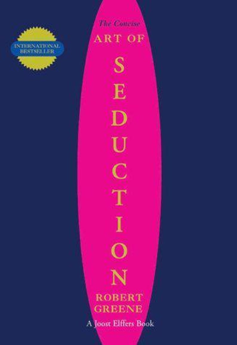 May include: A book cover with a dark blue background and a large, vertical hot pink oval in the center. The text reads The Concise ART OF SEDUCTION by Robert Greene, A Joost Elffers Book. A yellow starburst badge says INTERNATIONAL BESTSELLER.