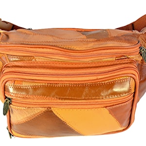 May include: A waist bag constructed from a patchwork of leather pieces in various shades of orange and brown. The bag features multiple zippered compartments with metal pulls, a main central pocket, and an adjustable strap with a plastic buckle.