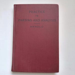 May include: A maroon-colored book titled "Practice in Parsing and Analysis" by Arnold. The book has a textured cover and the title is printed in dark gray. The book is closed and resting on a white surface.