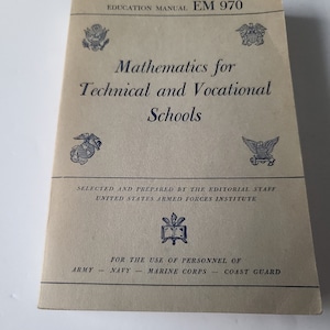 May include: A vintage book titled "Mathematics for Technical and Vocational Schools" with the text "Education Manual EM 970" at the top. The book is beige with blue text and images of military seals.