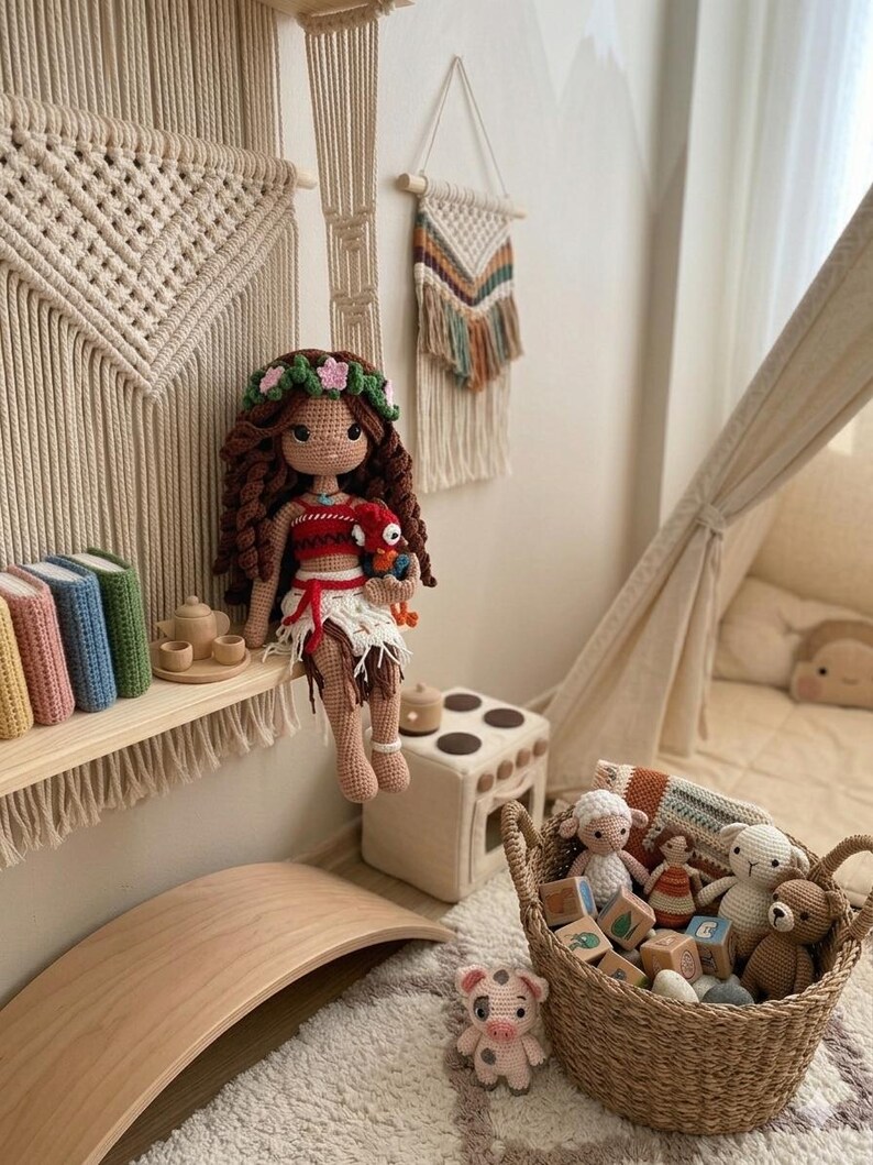 May include: A handmade crochet doll with long brown hair, a floral crown, and a red and white outfit. The doll is sitting on a shelf with books and a tea set. A basket filled with crochet toys and wooden blocks sits nearby.