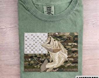 Camiseta de camuflaje con estampado de pesca, patchwork y bandera estadounidense de EE. UU. con diseño de pez lubina y pescador.
