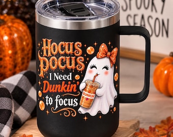 May include: A black stainless steel travel mug with a handle and a clear lid. The mug features a graphic of a white ghost wearing an orange bow, holding an iced coffee cup. Text reads: Hocus Pocus I Need Dunkin' to focus, with orange stars.