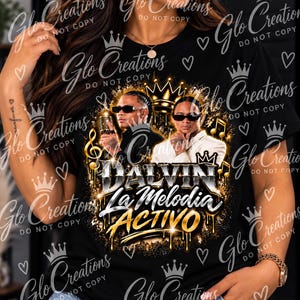 May include: A black t-shirt featuring a graphic print of two individuals wearing sunglasses, one holding a vintage microphone. The design includes a gold crown, musical notes, and the text DALVIN La Melodia ACTIVO in silver and gold lettering.
