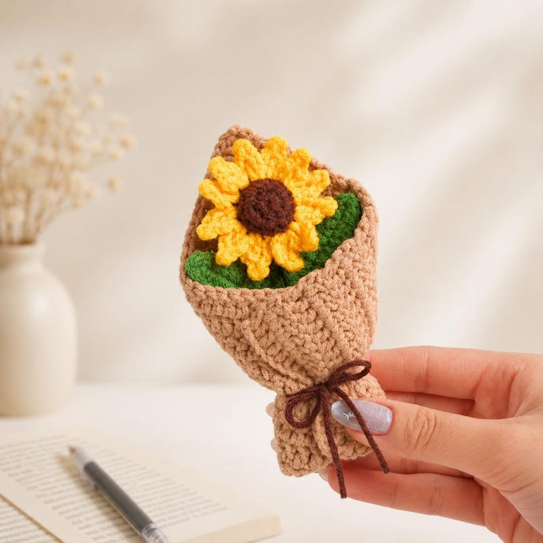 Crocheted sunflower bouquet with golden yellow petals and dark textured centers arranged with green leaves