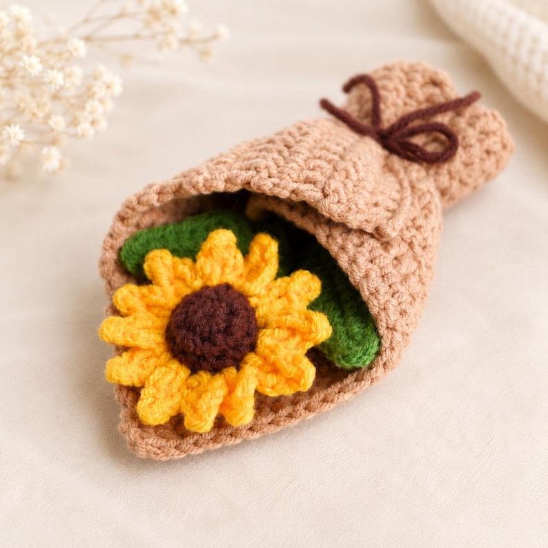 Close-up of a single crocheted sunflower showing textured brown center and pointed golden petals