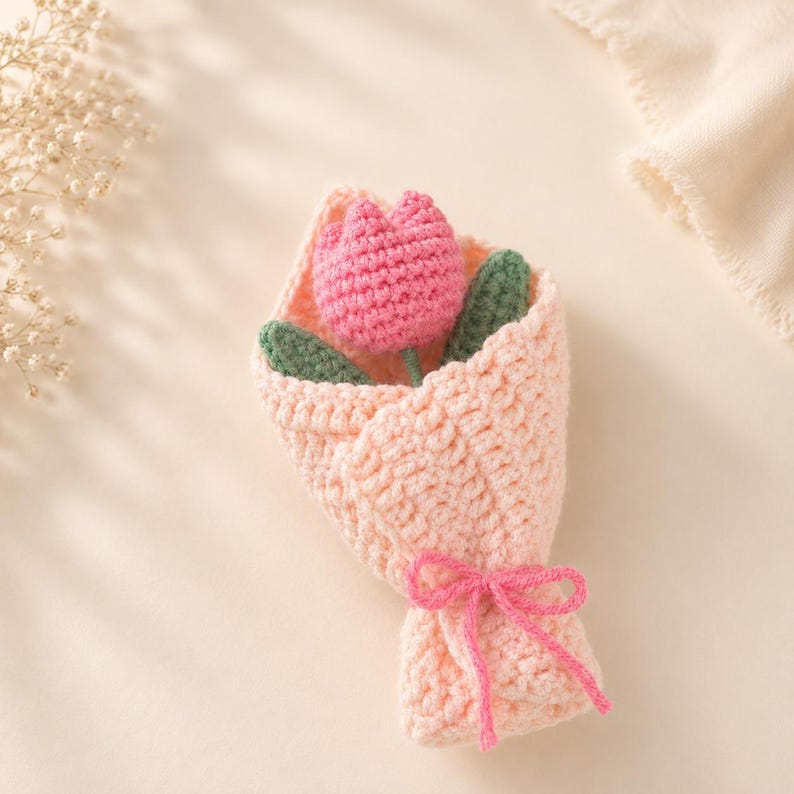 Multiple crocheted tulips in different colors bundled together with green crochet leaves and wired stems