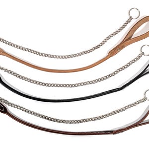 May include: Three dog leashes featuring a leather handle and a silver-toned metal chain section. Each leash includes a circular metal ring at both ends. The leashes are available in tan, black, and dark brown leather, each with white stitching.