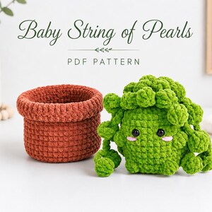 Puede incluir: Un patrón de ganchillo titulado Baby String of Pearls PDF Pattern que incluye una cesta de hilo color terracota y una planta suculenta de peluche verde con ojos negros y mejillas rosas, hecha con un punto de hilo grueso y texturizado.
