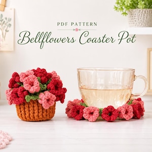 May include: A crochet PDF pattern titled Bellflowers Coaster Pot featuring a small orange pot filled with red and pink bell-shaped flowers and a matching circular coaster with a ring of red and pink flowers supporting a clear glass teacup.