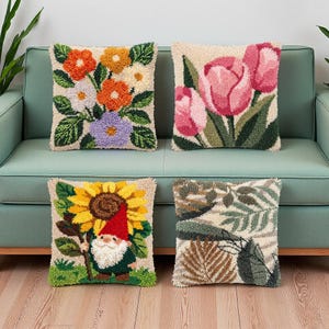 Könnte beinhalten: Vier quadratische Zierkissen mit strukturierter Punch-Needle-Stickerei. Eines zeigt einen bunten Blumenstrauß, ein weiteres rosa Tulpen, das dritte einen Zwerg mit einer Sonnenblume und das vierte ein Muster aus grünen und braunen Blättern.