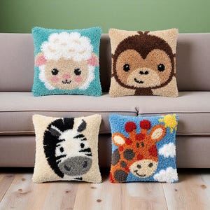 May include: Four square throw pillows featuring textured punch needle designs of animal faces. The top left is a white sheep on teal, top right is a brown monkey on tan, bottom left is a black and white zebra on cream, and bottom right is a giraffe.