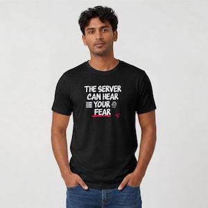 May include: A black short-sleeved t-shirt featuring the white text THE SERVER CAN HEAR YOUR FEAR, accompanied by a small graphic of a server rack, an ear icon, and a red brushstroke underline with a small red signature mark on the chest.