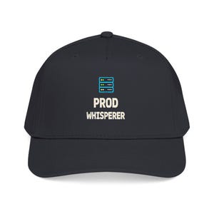 May include: A dark charcoal baseball cap featuring a graphic of a server rack with blue outlines and yellow and green status lights, positioned above the white text PROD WHISPERER centered on the front panel of the structured crown.